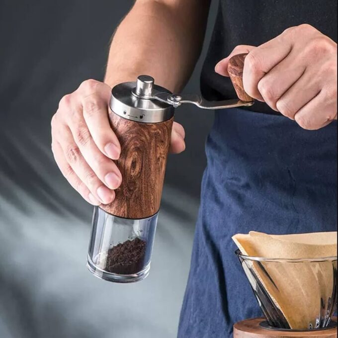 A man using a manual coffee grinder
